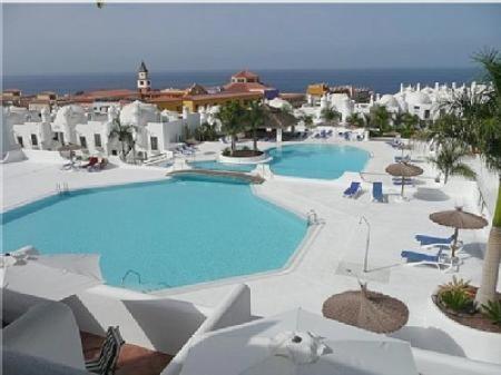 een groot zwembad met parasols en stoelen in een resort bij Adeje Paradise dreams in Playa Paraiso