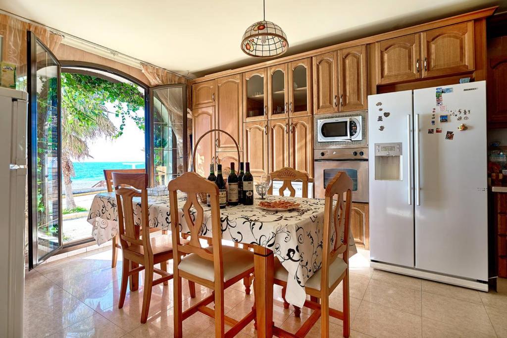cocina con mesa y nevera blanca en Casa de Sueño en la Playa, en Adra