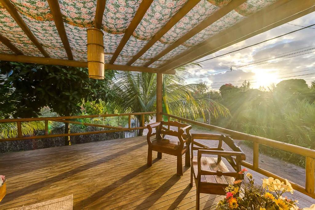 una terraza de madera con 2 sillas y puesta de sol en Pousada Brisa Da Barra, en Barra Grande