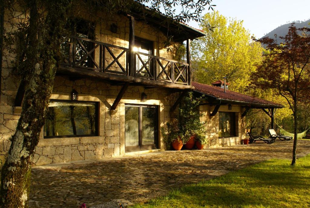 a stone house with a balcony on the side of it at Quinta do Caneiro in Geres