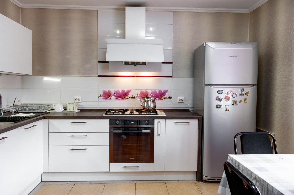 a kitchen with a stove and a refrigerator at Hostel Astana in Astana