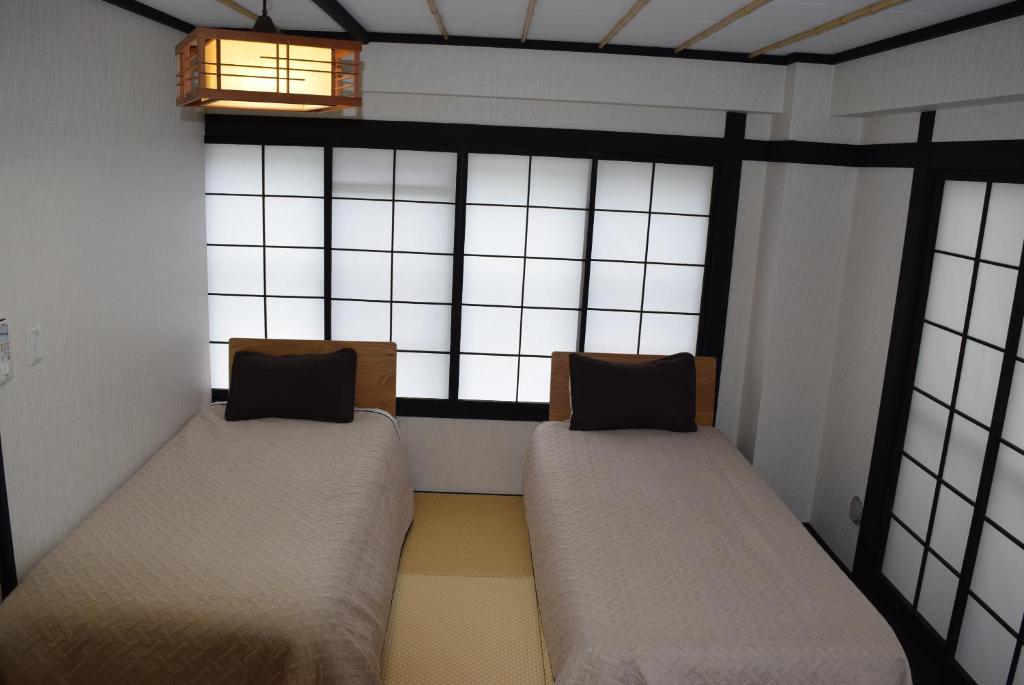 Postel nebo postele na pokoji v ubytování Nozawa Onsen BASECAMP