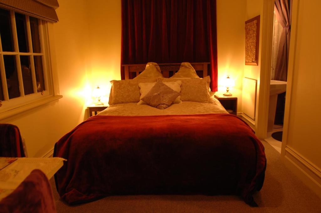 a bedroom with a large bed with pillows on it at Laurel Bank House in Queenstown