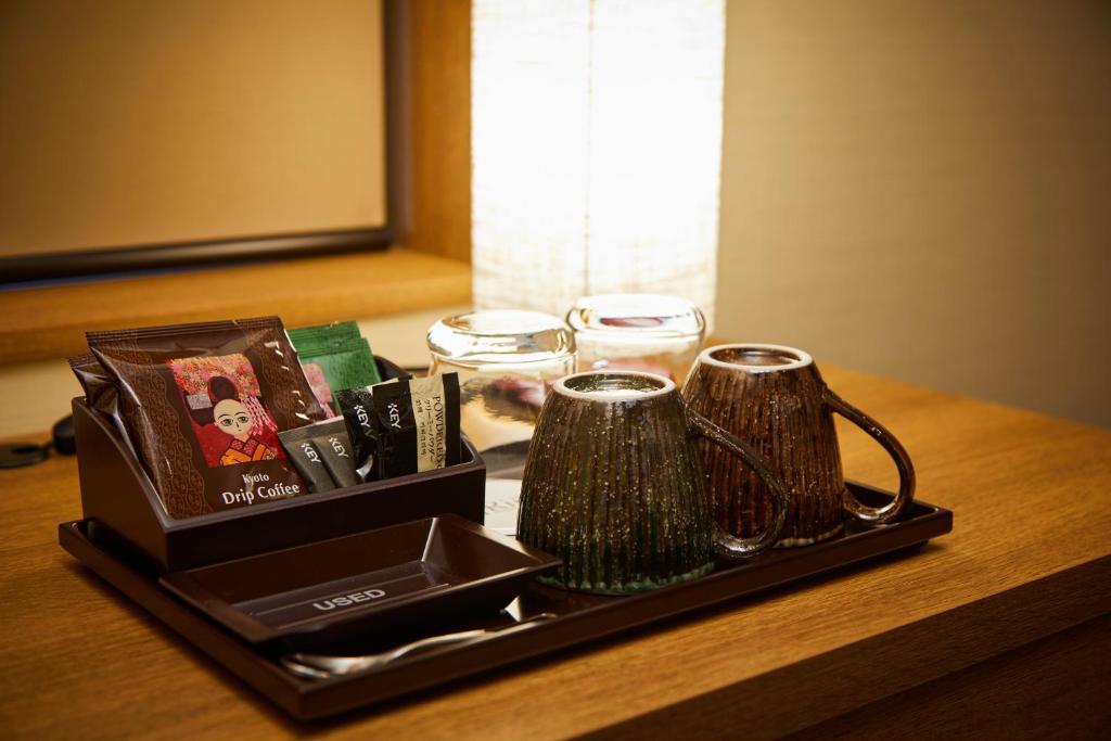 a tray with two mugs and books on a table at Rinn Gion Kenninji in Kyoto