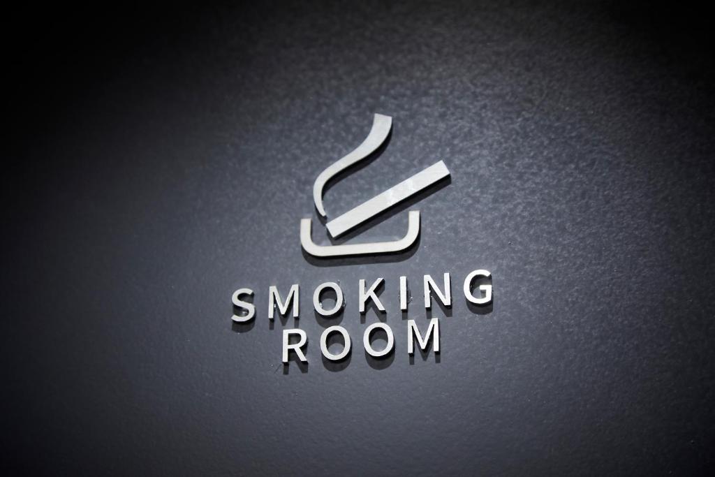 a logo for a smoking room with a smoking arrow at Rinn Gion Kenninji in Kyoto