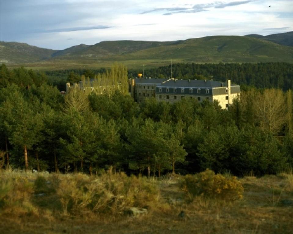 ein Gebäude inmitten eines Feldes mit Bäumen in der Unterkunft Parador de Gredos in Navarredonda de Gredos