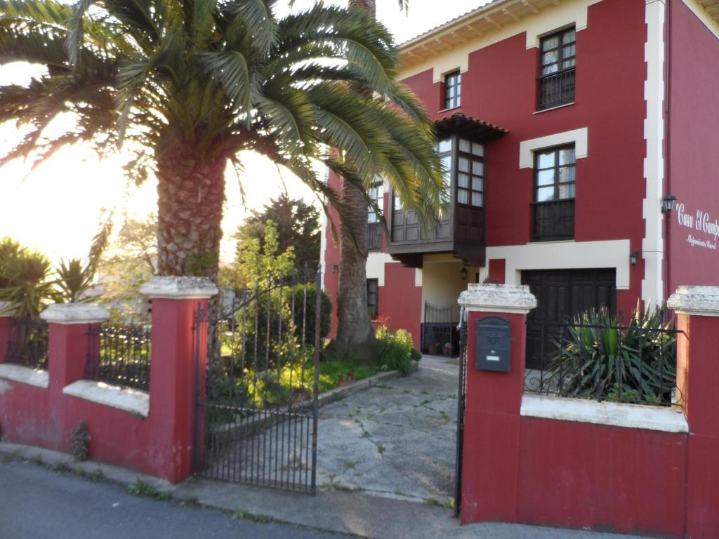 a palm tree in front of a red building at Casa El Campu in Infiesto