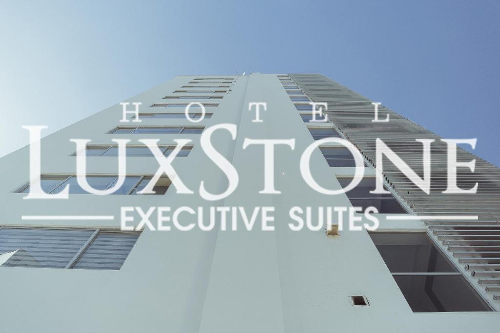 un edificio alto con las palabras suites ejecutivas london en Luxstone Executive & Suites, en La Paz