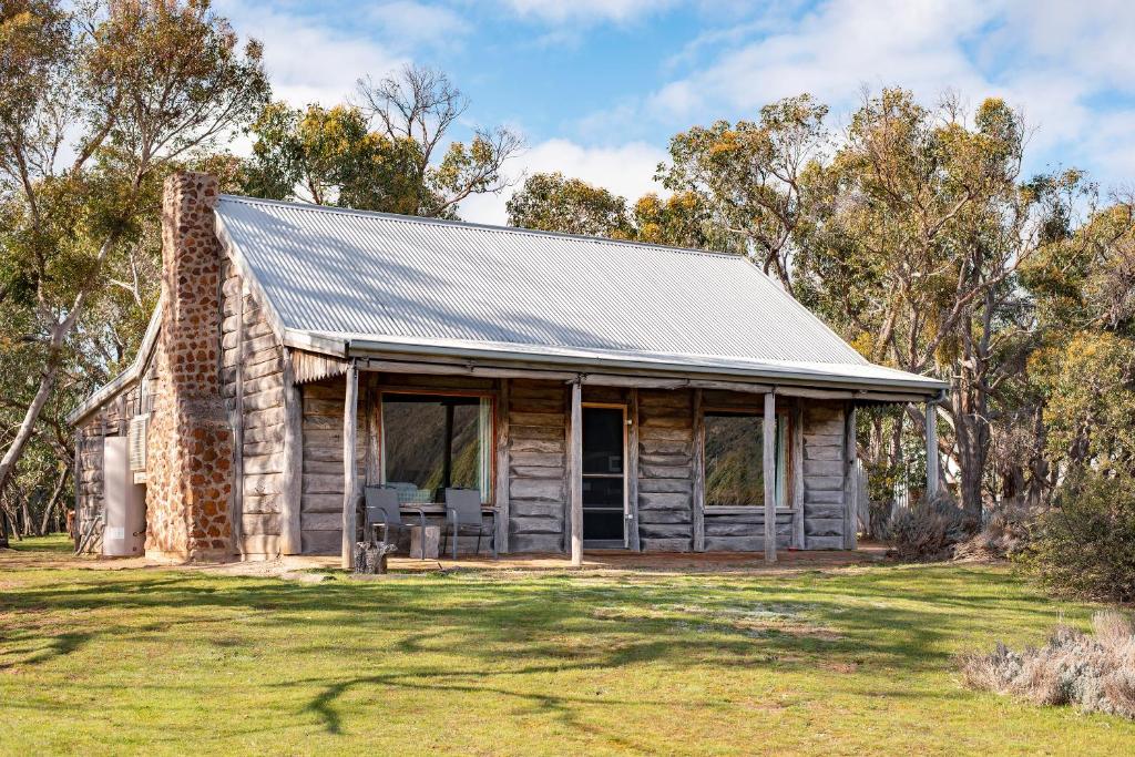 an old log cabin with a metal roof at Grampians Pioneer Cottages in Halls Gap