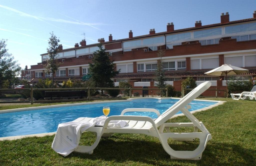 einen Tisch und einen Stuhl neben einem Pool in der Unterkunft PARK SEDO Aparthotel in Rubí