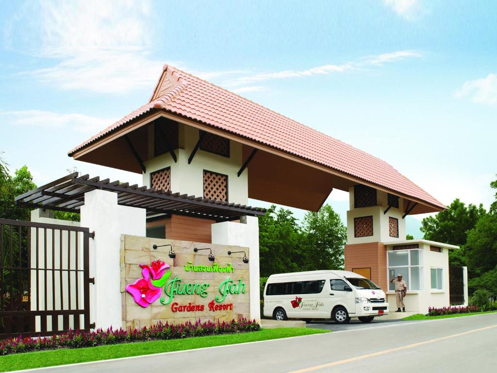 un gran edificio con un cartel delante en Fueng Fah Riverside Gardens Resort, en Mae Rim