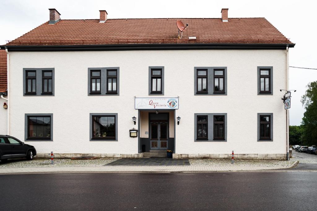 a white building with a brown roof at Landgasthaus Queen Victoria in Stadtilm