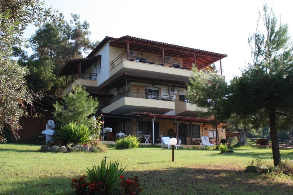 une grande maison avec une pelouse devant elle dans l'établissement Bambola Apartments by Booking Kottas, à Nea Moudania