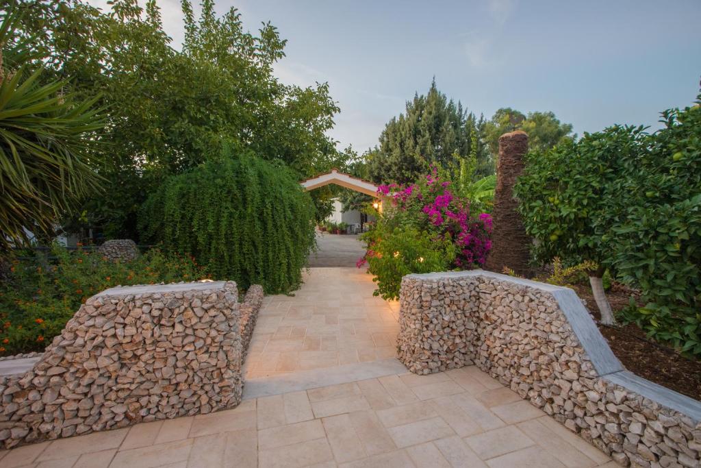 a garden with two benches and trees and flowers at Lila's house in Eleoúsa