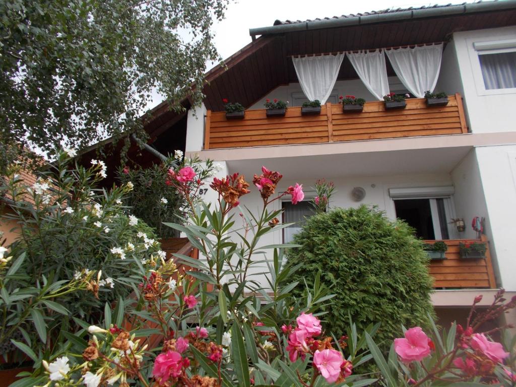 a house with a balcony with flowers in front of it at Nimród Pihenőház in Egerszalók