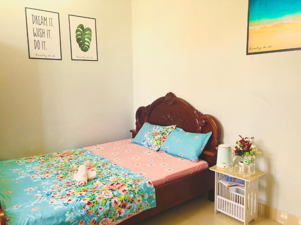 een kleine slaapkamer met een bed met bloemen erop bij Homestay An An in Vung Tau