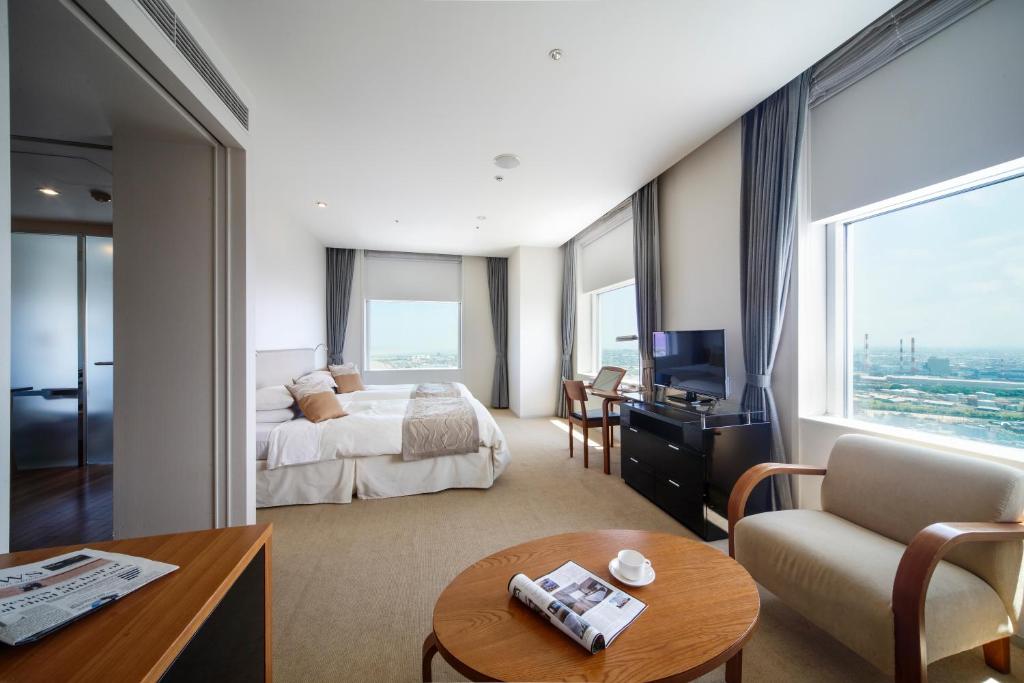 a hotel room with a bed and a couch and a table at Hotel Nikko Niigata in Niigata