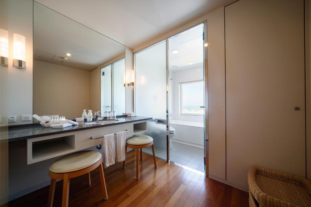 a bathroom with a counter with two stools and a sink at Hotel Nikko Niigata in Niigata