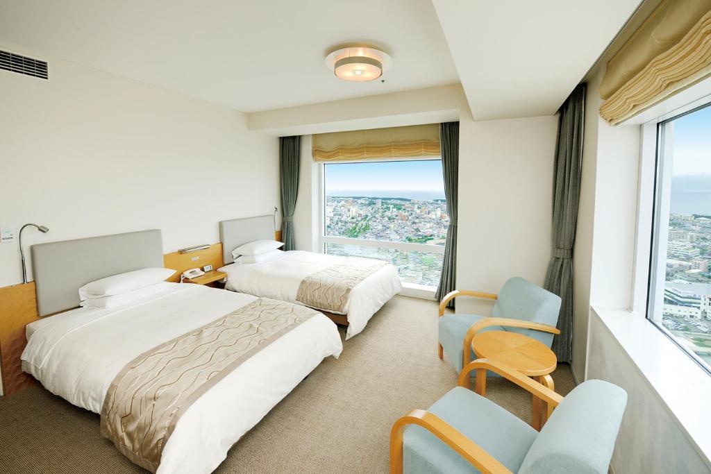a hotel room with two beds and a window at Hotel Nikko Niigata in Niigata
