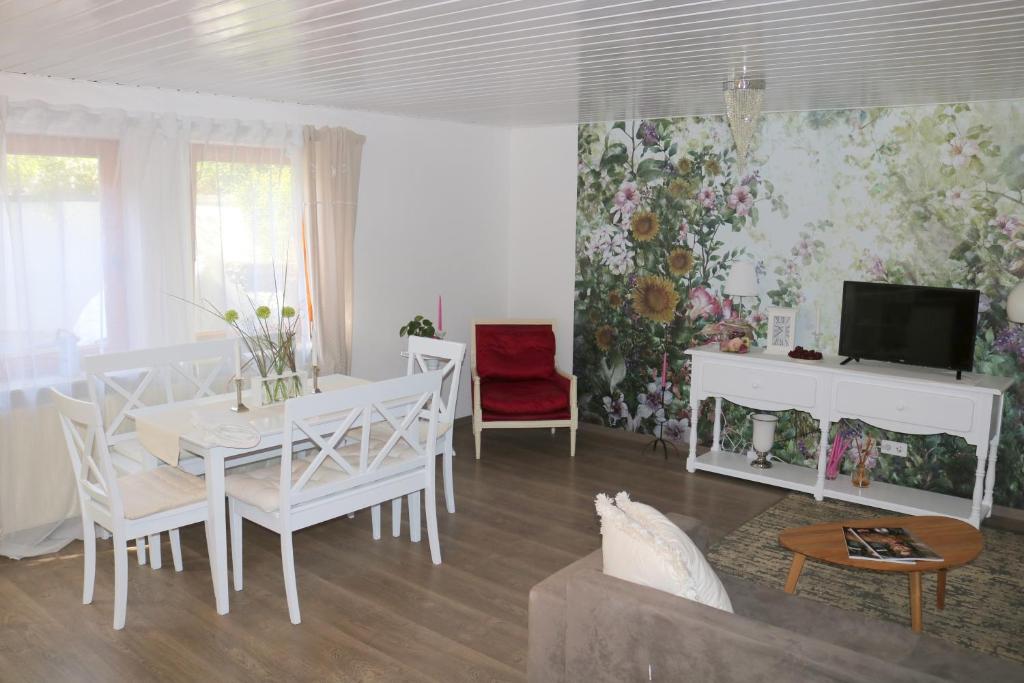 een woonkamer met een witte tafel en een tv bij Soutterain - Wohnung mit Senkgarten in Weingarten (Karlsruhe)