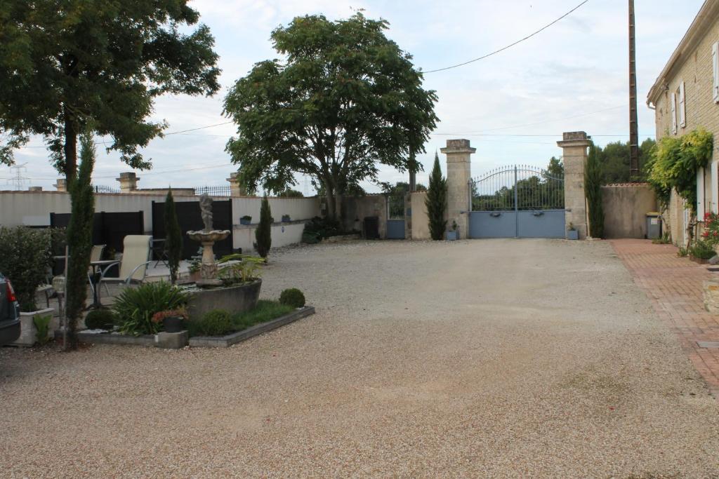 an empty driveway with a gate and a fence at Le Logis d&#39;ANTIGNY in Val-du-Mignon