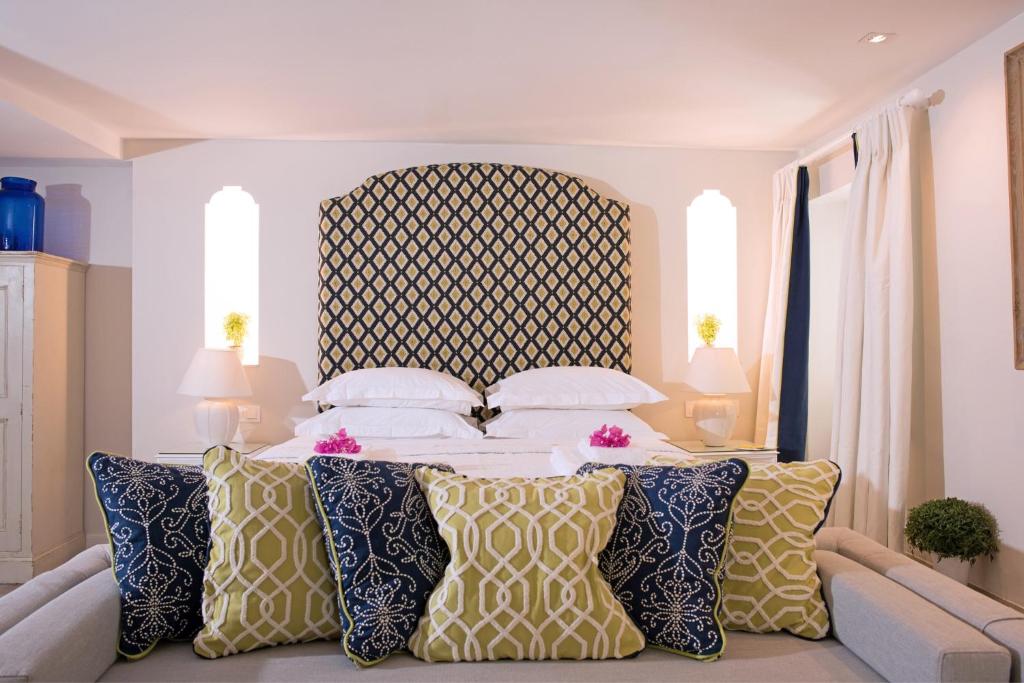 ein Schlafzimmer mit einem großen Bett mit Kissen in der Unterkunft Theotoki Liston Suite in Korfu-Stadt