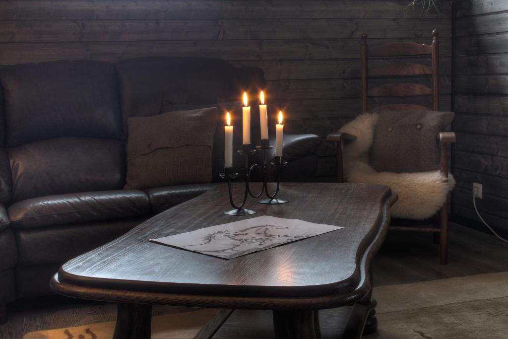 a coffee table with two candles and a couch at Olkka ranch in Mustakulkkula