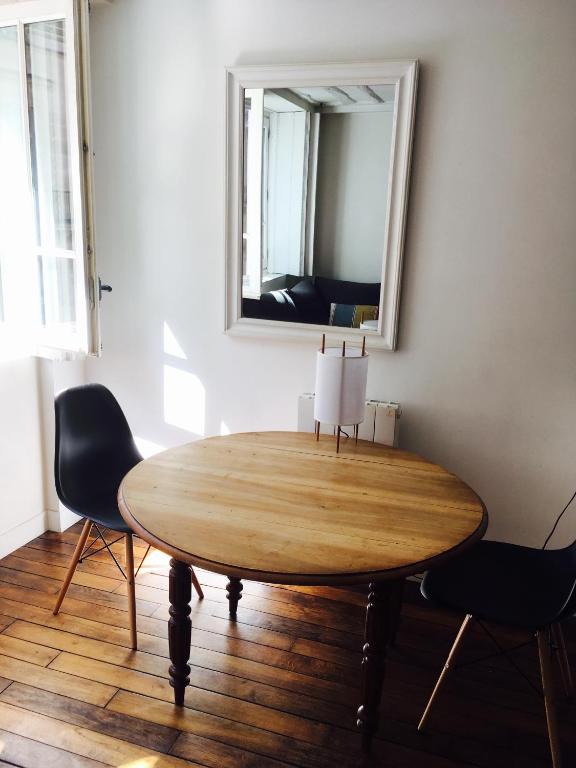 a table in a room with a mirror and chairs at Chez Vous ST HONORÉ in Paris