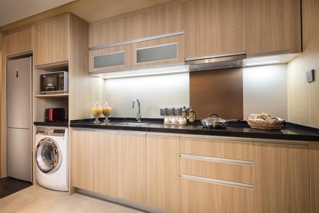 a kitchen with a sink and a washing machine at Somerset Harmony City Wuxi in Wuxi