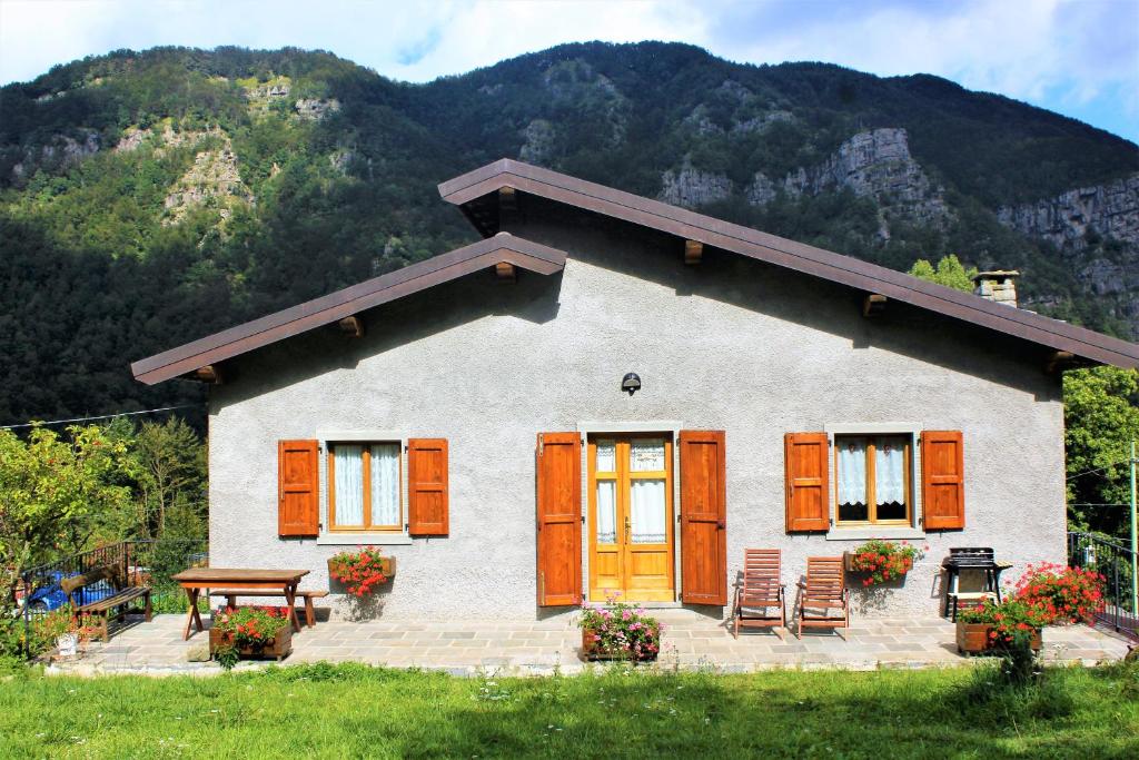 a house with orange doors and a table and chairs at Chalet Abetone in Tuscany in Abetone