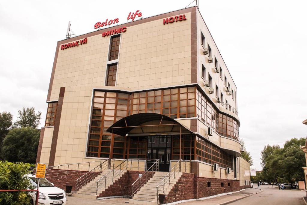 un grande edificio con scale di fronte di Belon Life Hotel a Astana