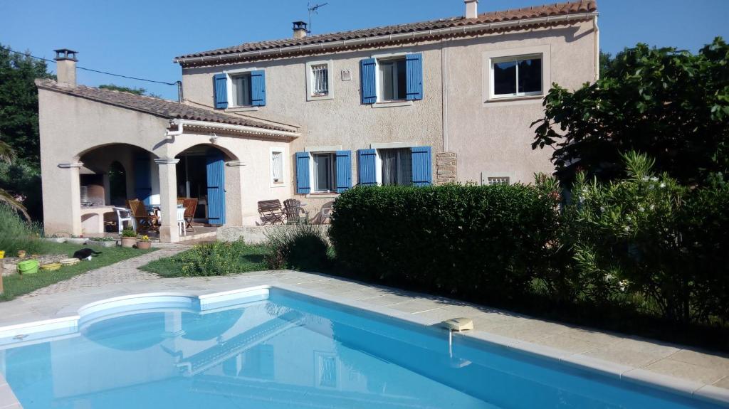 uma casa e uma piscina em frente a uma casa em Gite touristique em Piolenc