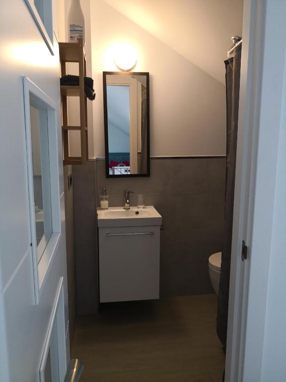 a bathroom with a sink and a mirror and a toilet at Apartamentos en Paseo Maritimo in El Rompido