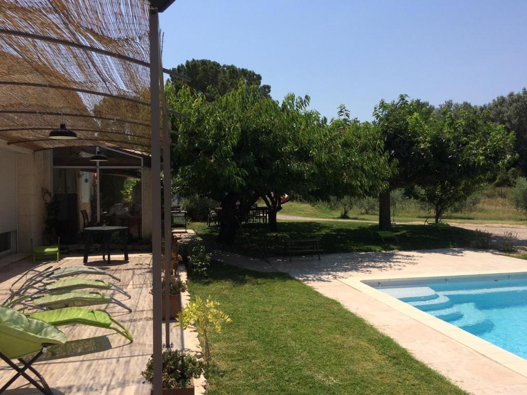 une arrière-cour avec une piscine et des arbres dans l&#39;établissement Le Mazet Des Joncs en Provence, à Saint-Pierre-de-Vassols