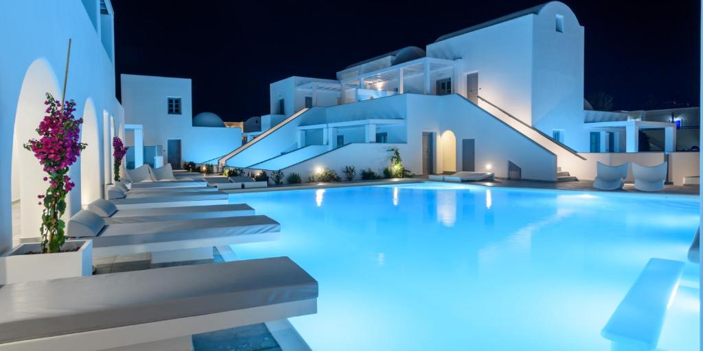 una piscina por la noche con edificios blancos en Antoperla Luxury Hotel & Spa, en Perissa