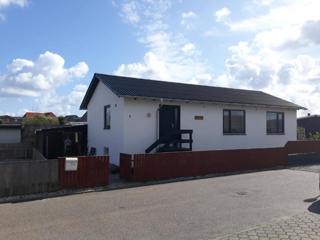 a white house with a red fence at Apartment Fanny in Hvide Sande