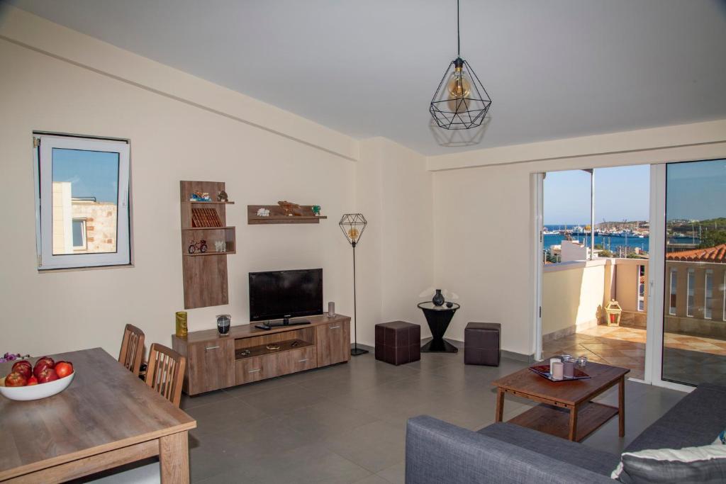 a living room with a couch and a tv at Catherine's Comfort Apartment Νο3 in Lavrio