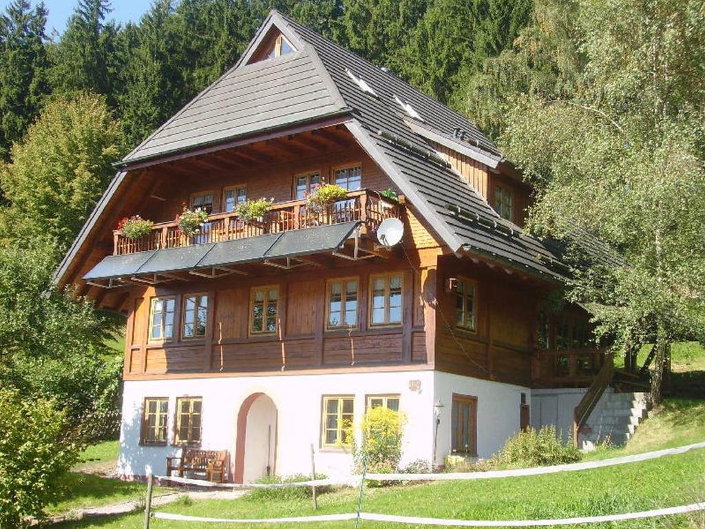 a large wooden house with a balcony on top of it at Am Neuhausbauernhof in Königsfeld im Schwarzwald