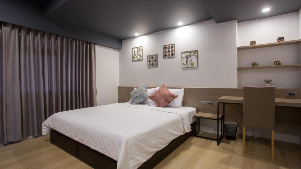 Habitación de hotel con cama y escritorio en Toptel Thaphra - ท็อปเทล ท่าพระ en Bangkok