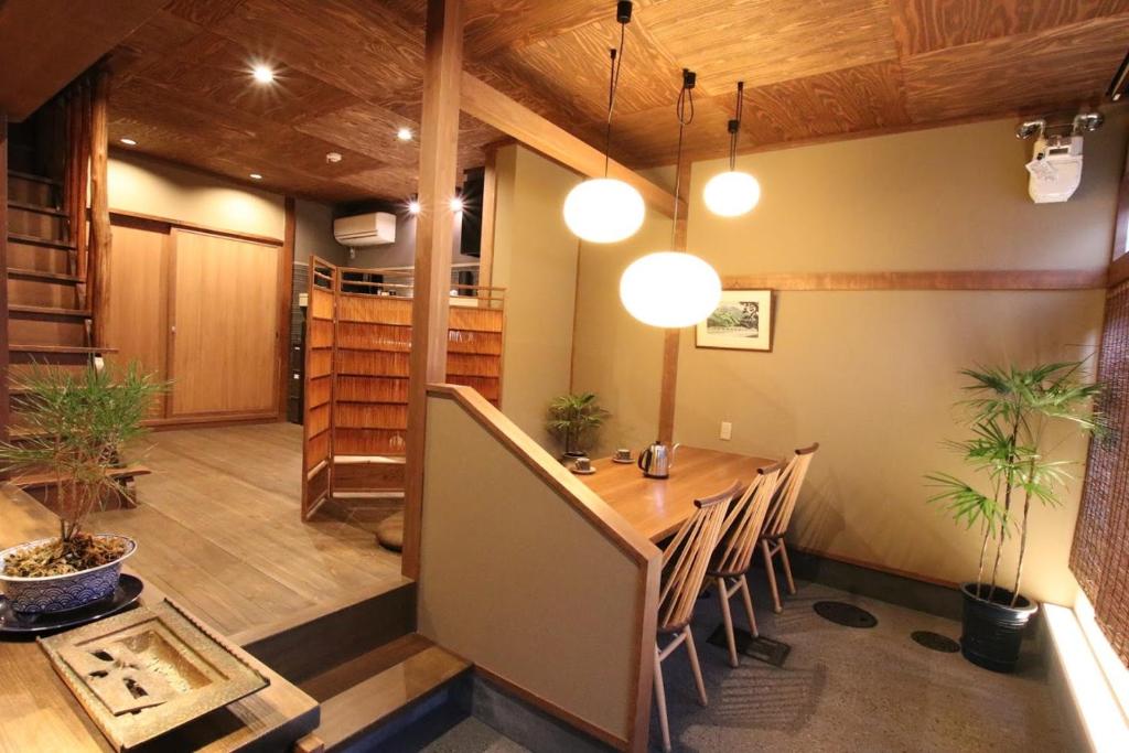uma sala de jantar com uma mesa e algumas plantas em Guest House Sawaragi em Quioto