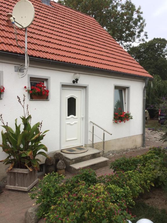 ein kleines weißes Haus mit rotem Dach in der Unterkunft FeWo Karnitz/Rügen in Karnitz