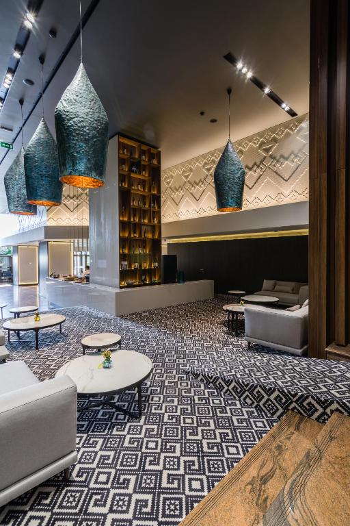 a lobby with couches and tables in a building at Unirea Hotel & Spa in Iaşi