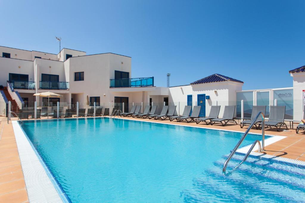 a swimming pool in front of a building at TAO El Cotillo in El Cotillo