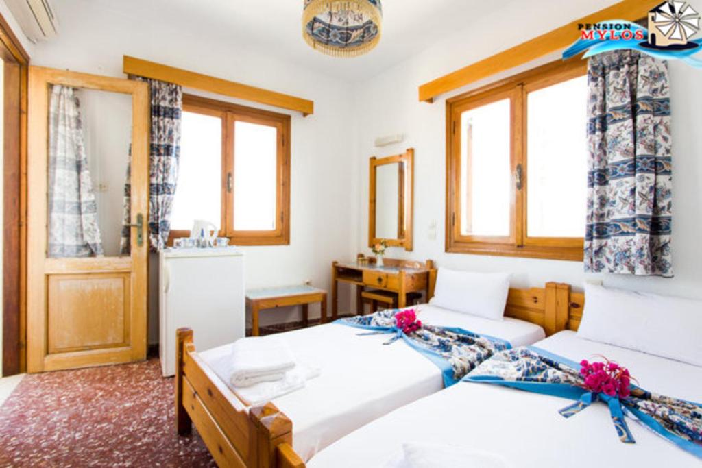 1 dormitorio con 2 camas y lavamanos en Pension Mylos, en Agios Nikolaos