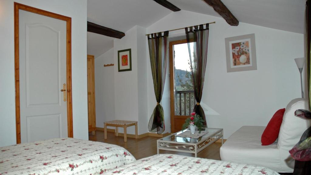 a bedroom with a bed and a table and a window at Chambres d&#39;hôtes La Hulotte 69 in Villechenève