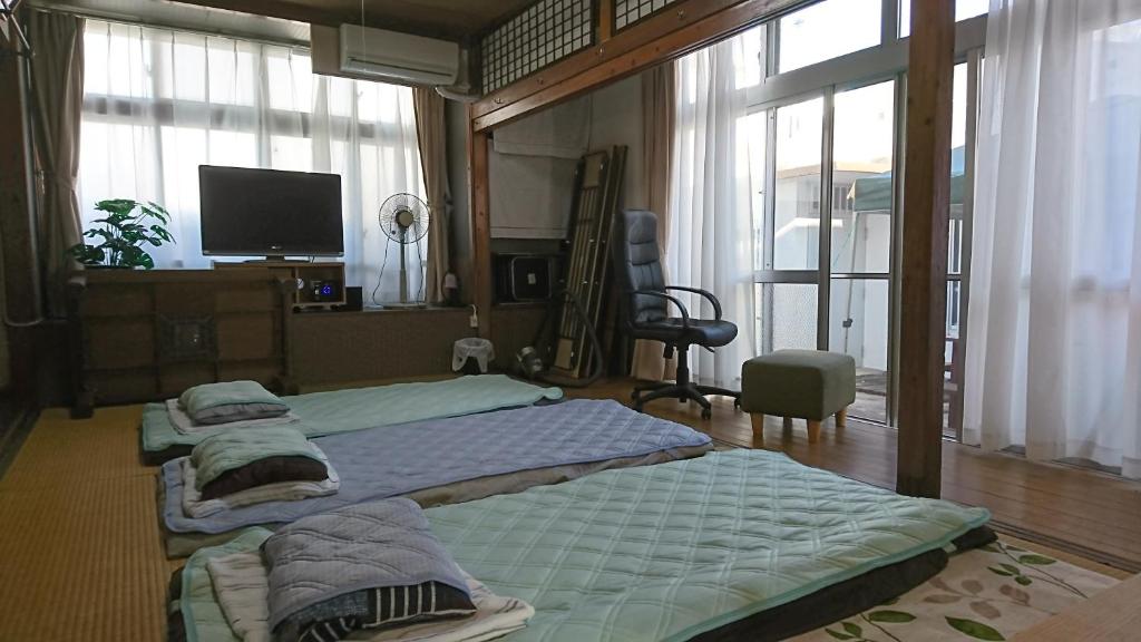 糸满民宿 ＯＢ（guest house OB）的一间卧室设有两张床、一台电视和窗户。