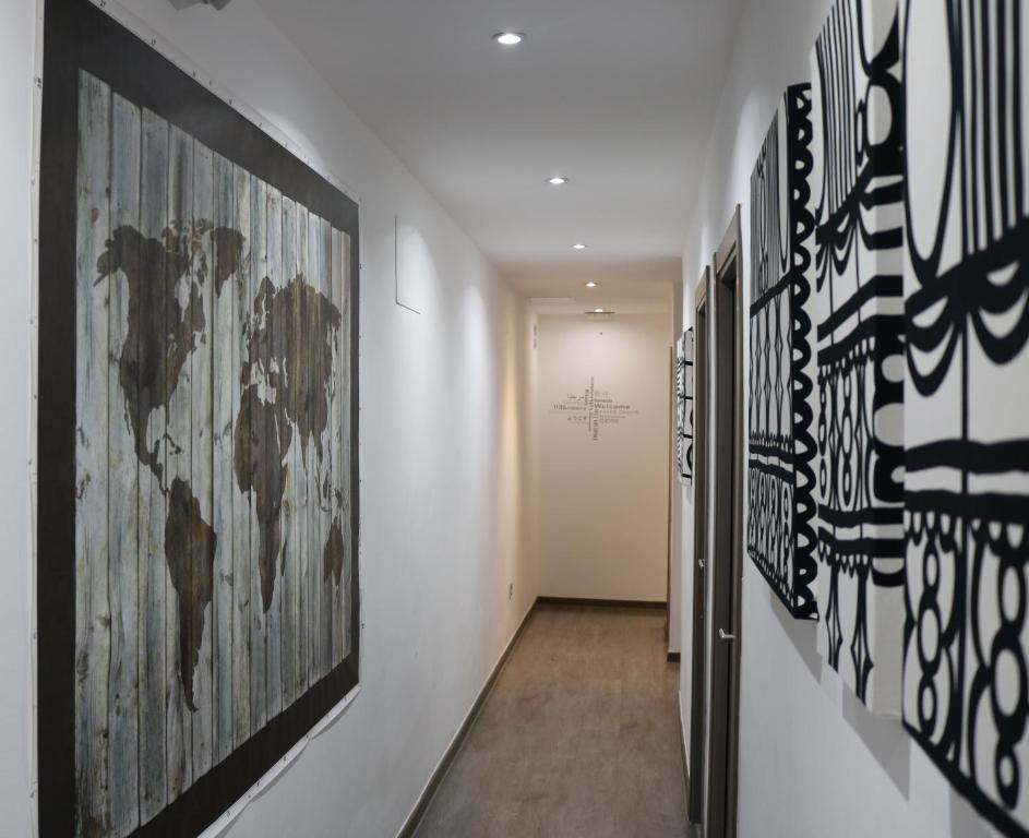 einen Flur mit einem Haufen Kunst an den Wänden in der Unterkunft Hostal Abril Madrid in Madrid