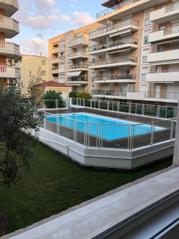 - une vue extérieure sur un bâtiment avec une piscine dans l'établissement Palais des domes, à Nice