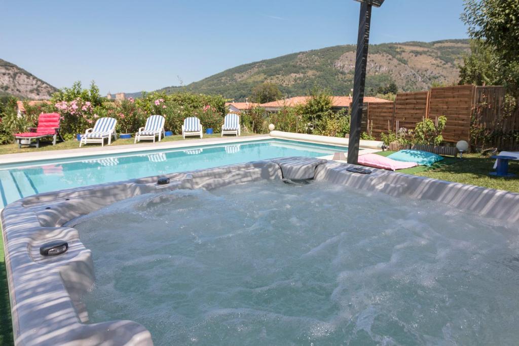 una piscina con sillas en un patio con montañas en Villa Georges, en Foix