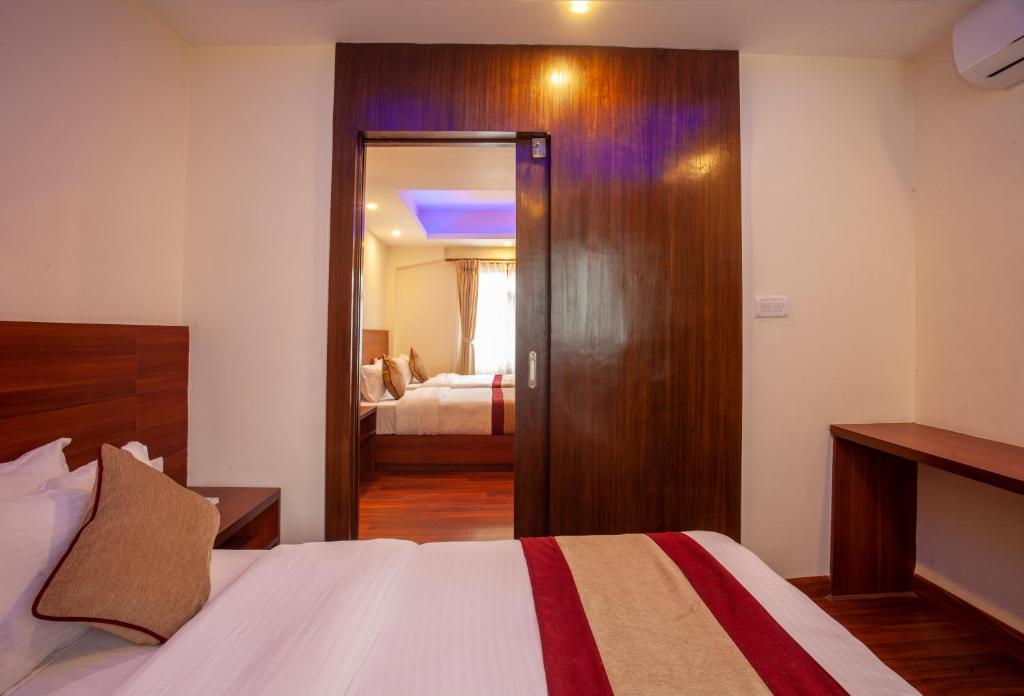 Postel nebo postele na pokoji v ubytování Aryatara Kathmandu Hotel